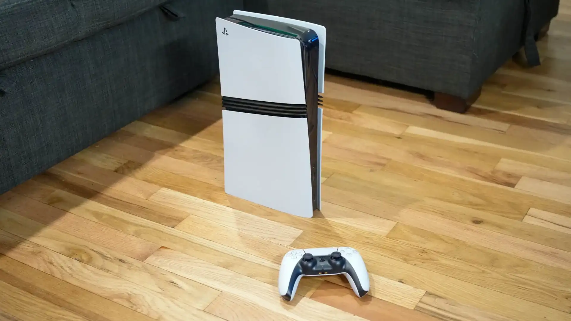 “Two gaming consoles, PS4 and PS5, placed side-by-side in a dark room with glowing blue digital light trails connecting them to represent cross-console connectivity.”